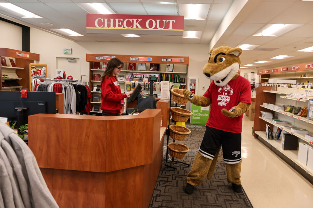 Butch T. Cougar mascot wearing a graduation cap and gown.