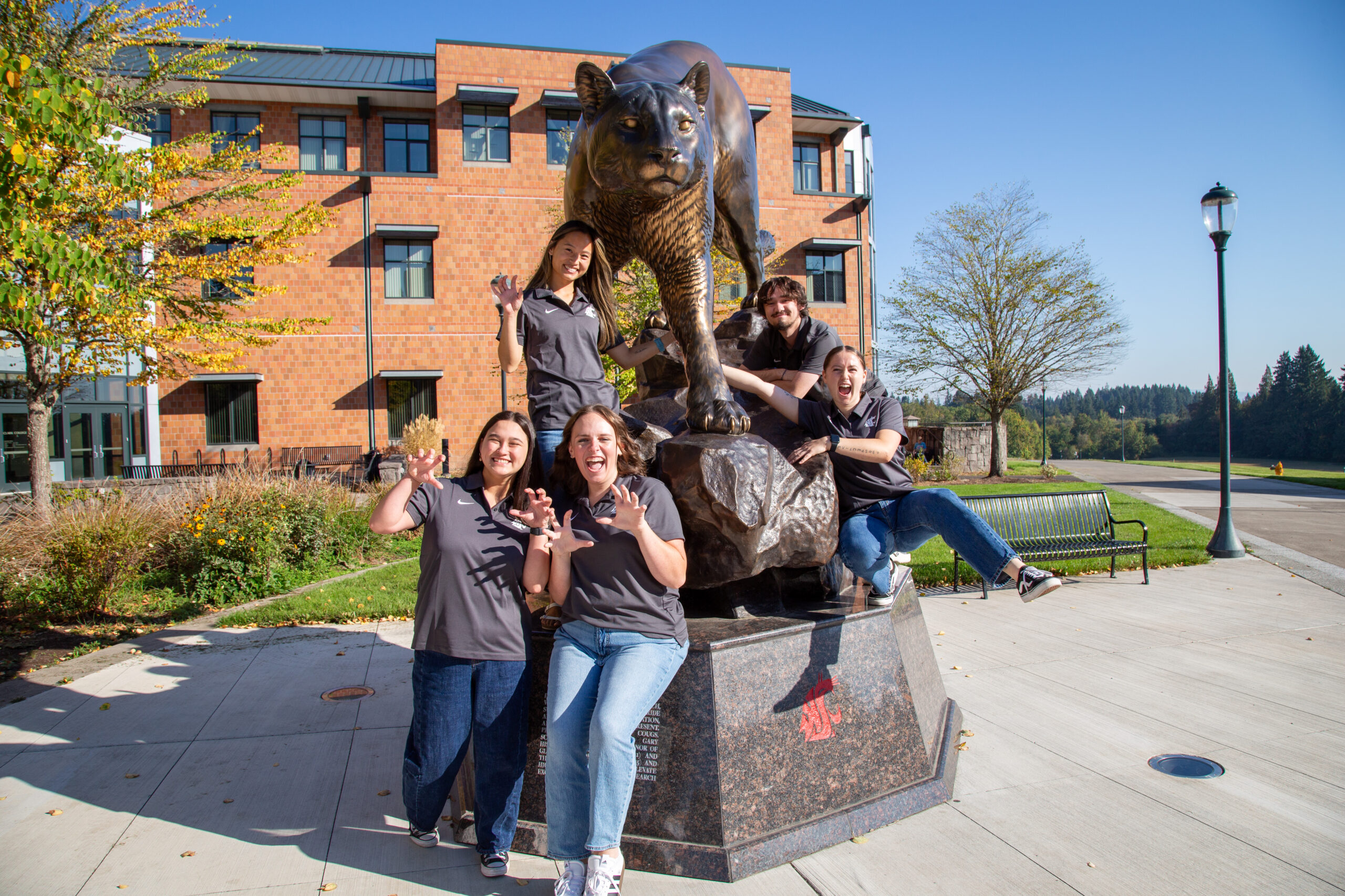 A small group of students sitting on steps outside a brick building
