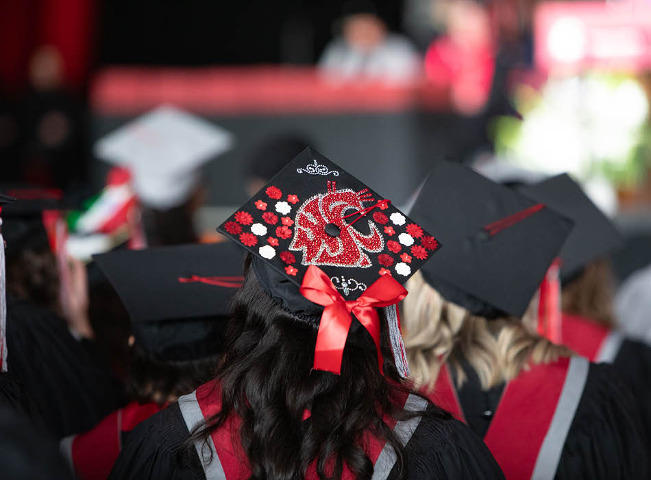 A close-up view of a graduate wearing a customized graduation cap at a commencement ceremony