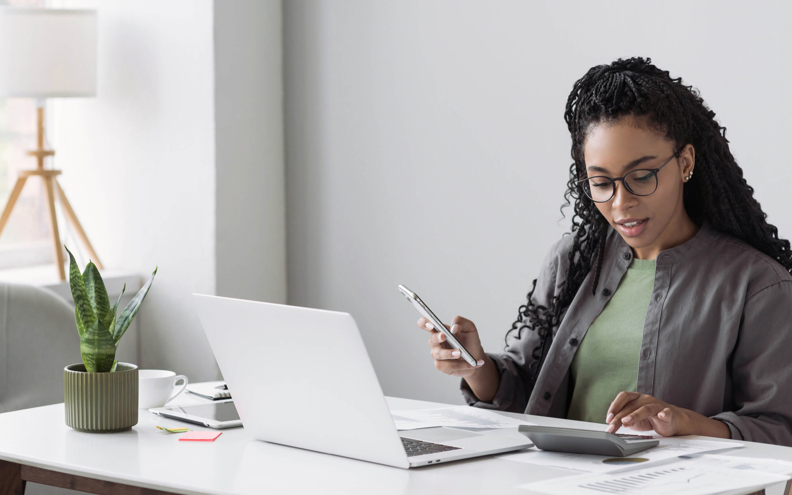 A professional working on a laptop at her office desk on the WSU Vancouver campus