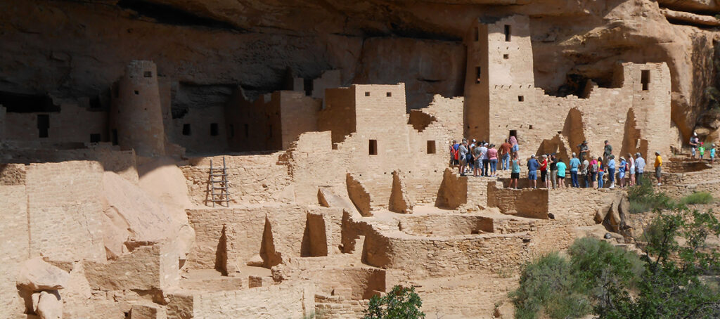 An educational presentation slide displaying ancient cliff dwelling archaeological sites
