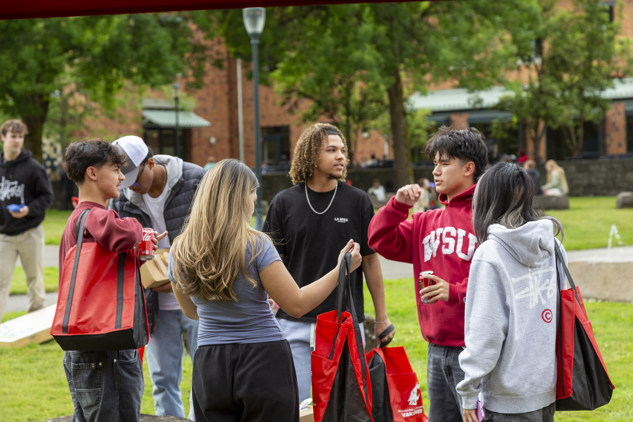 Students gathering and chatting outside an academic brick building