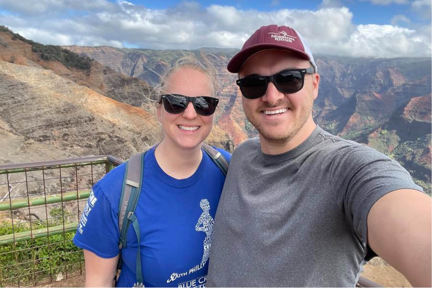Two individuals smiling together with a scenic mountain range background