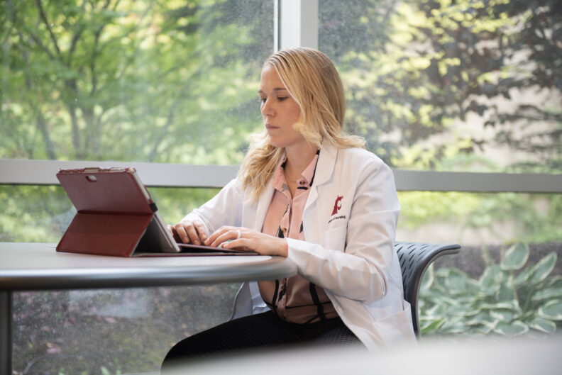 A professional woman working diligently on her laptop at a desk on the WSU Vancouver campus