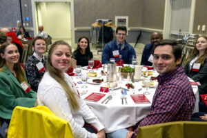 A group of students posing together around a banquet table at a WSU Vancouver campus gala