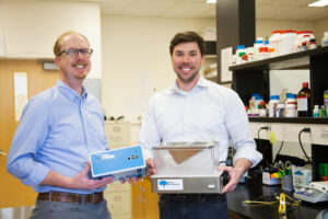 Two professionals or scientists interacting in a laboratory setting