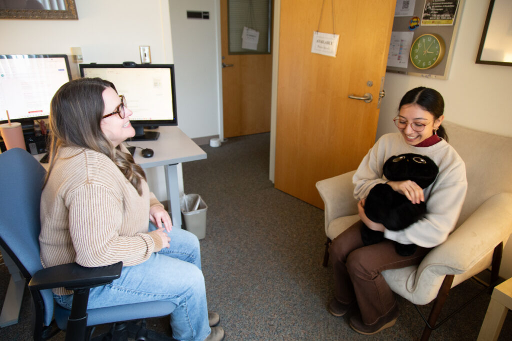 Two women sitting in an office environment having a conversation