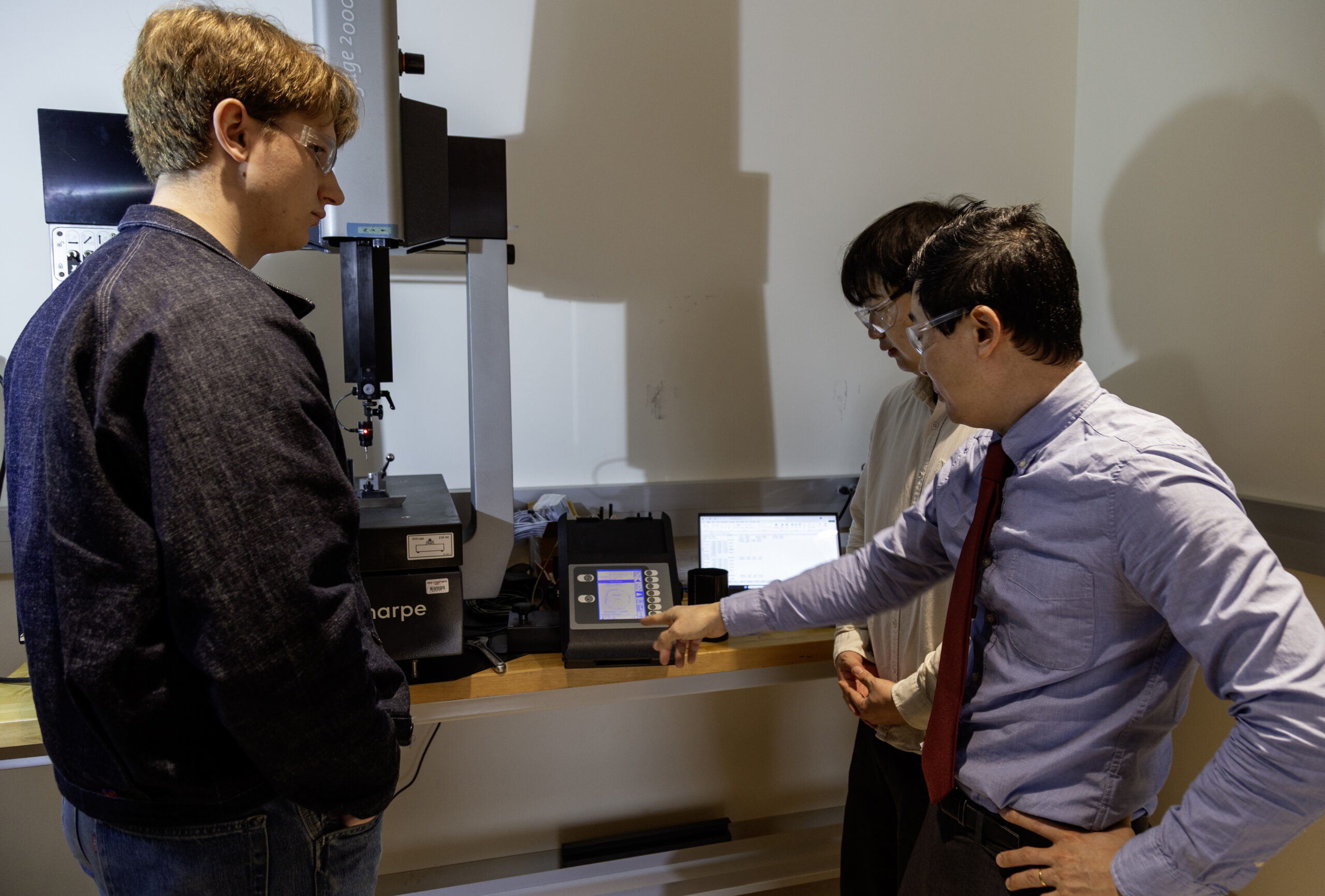 Two engineers monitoring systems on a precision alignment rail instrument at WSU Vancouver