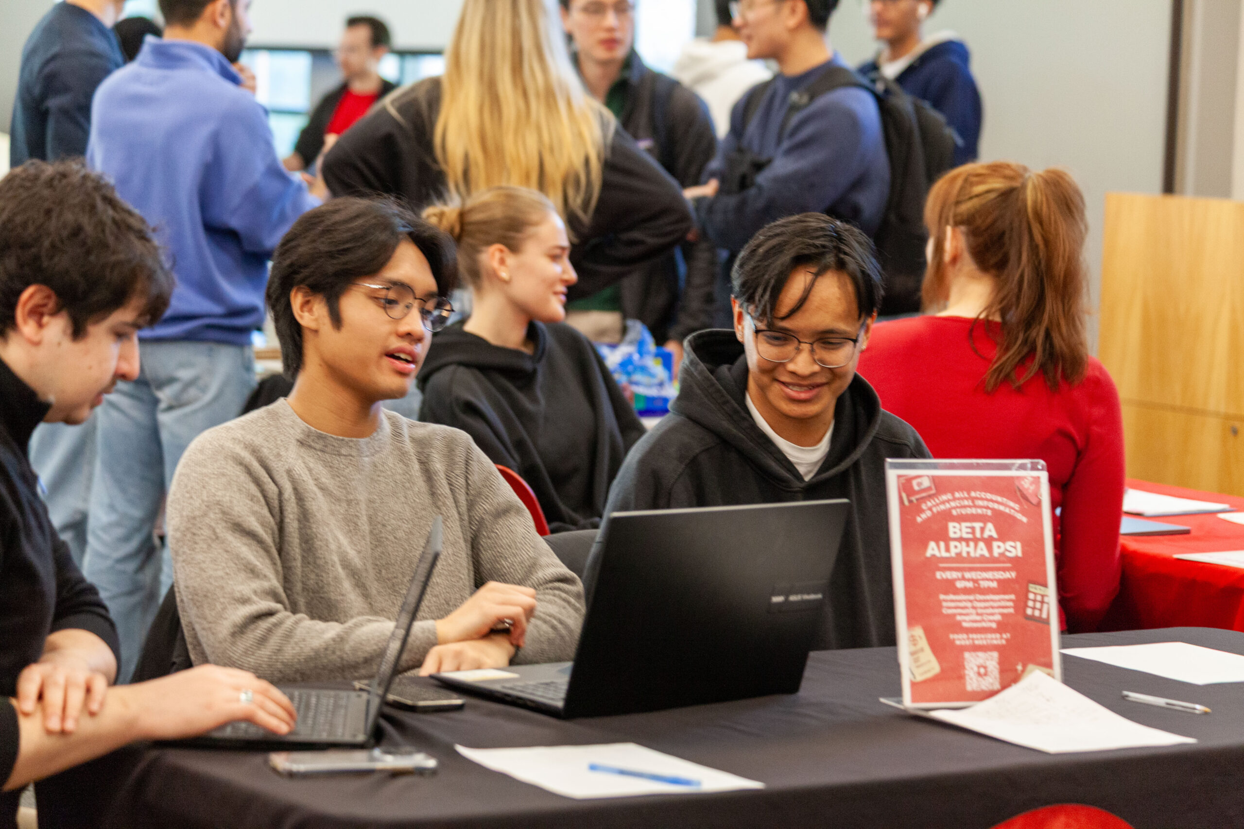 Students sitting and collaborating around a table in a university building