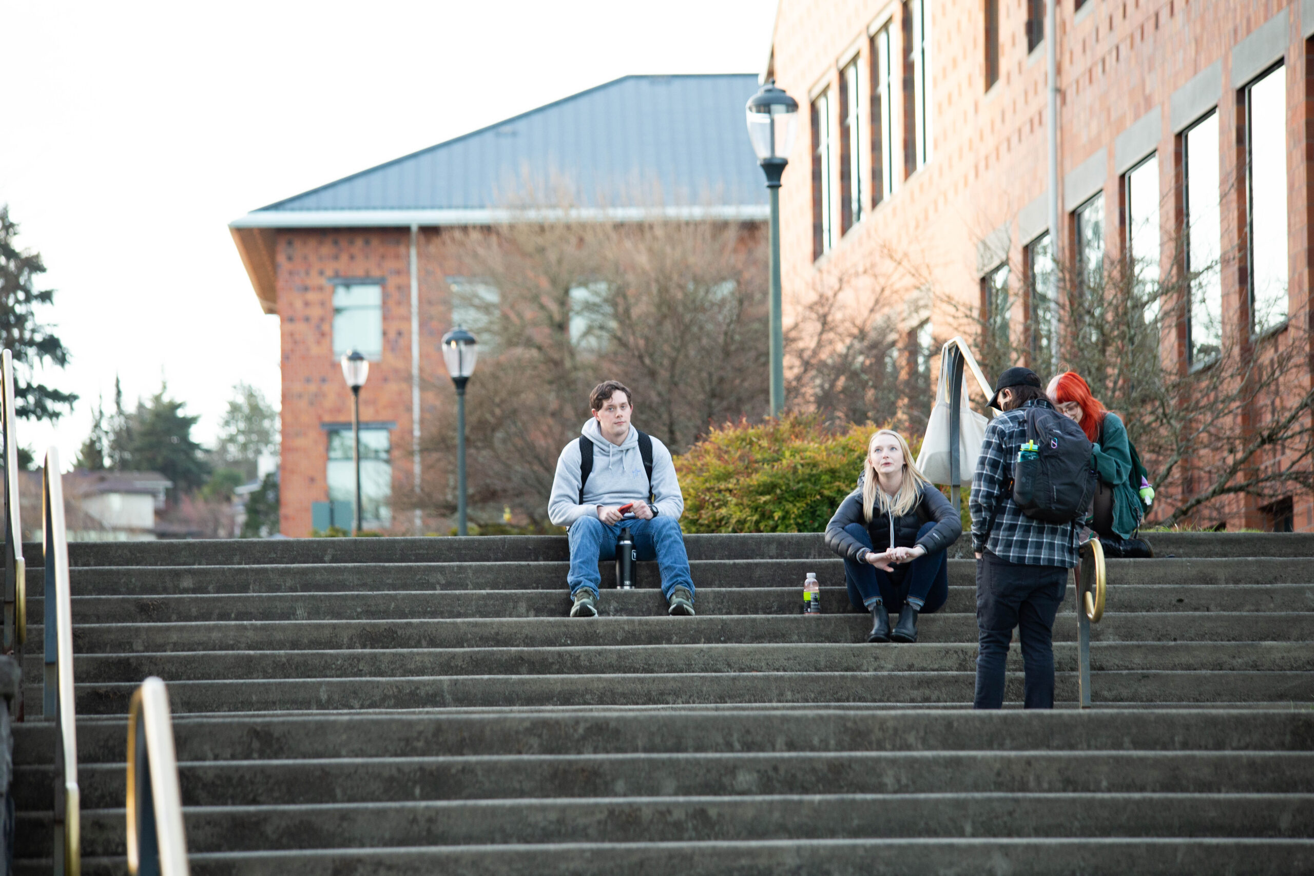 Students walking down large stone outdoor steps on a campus