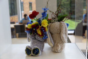 A close-up of a colorful floral arrangement sitting on a table outdoors