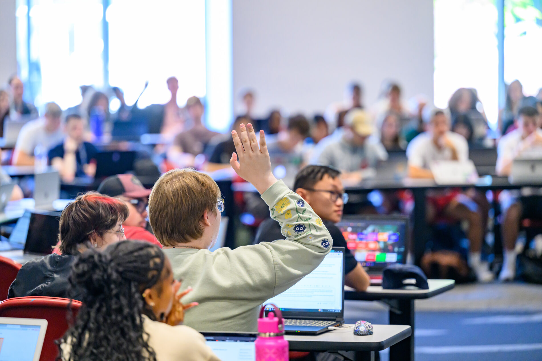 An indoor view of a crowded auditorium or lecture hall during an event presentation