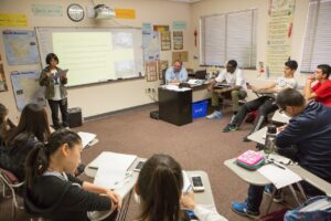 A WSU Vancouver seminar style classroom with students and a faculty member gathered around a table
