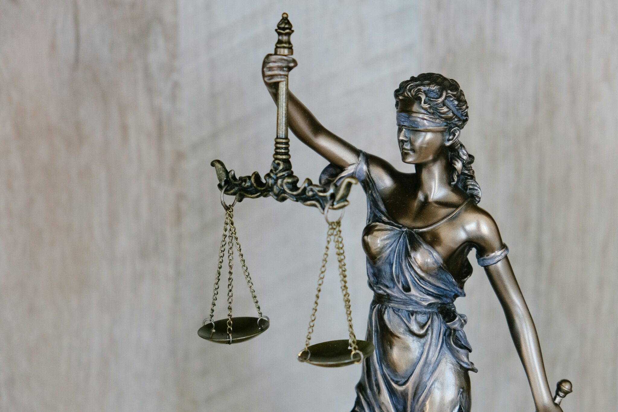 Close-up of a bronze Lady Justice statue holding scales of justice