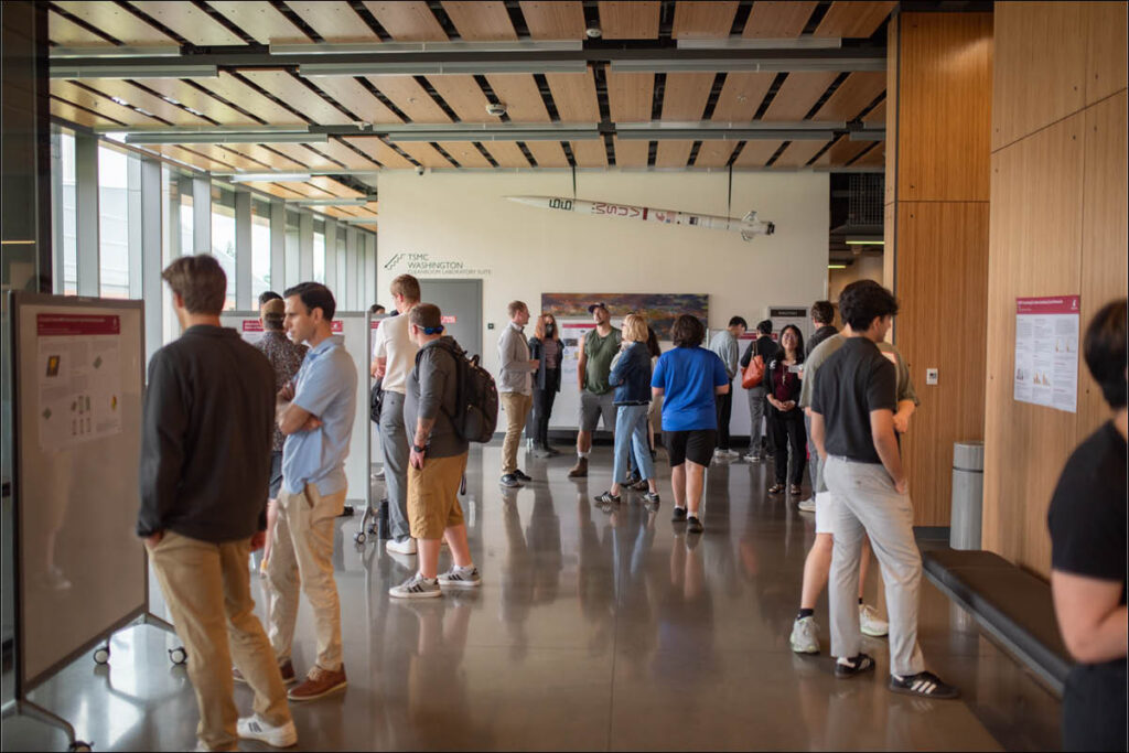 A group of people standing and talking in a modern campus corridor