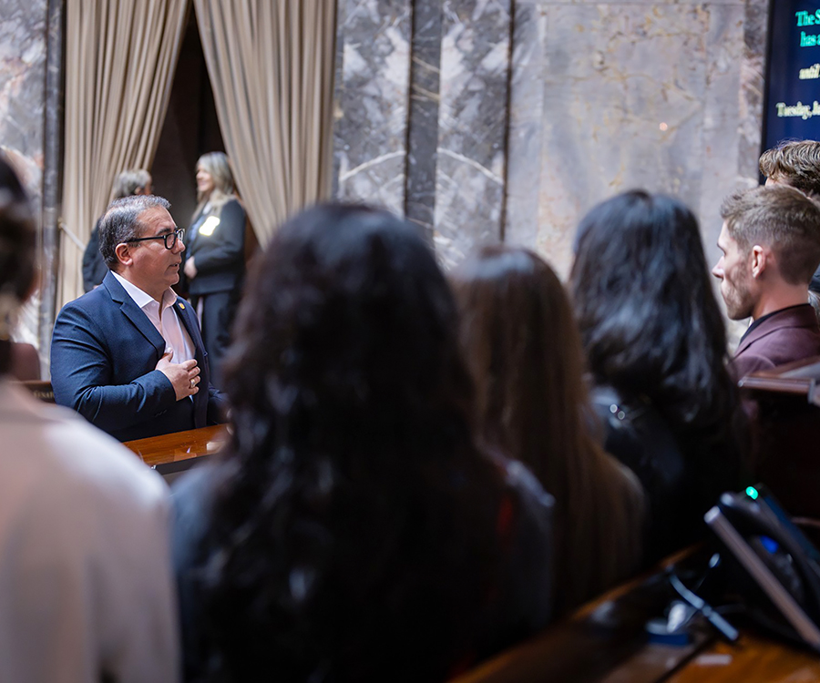 Five ASWSUV student government members sit and listen to a Washington state senator speak during a visit to the Capitol building in Olympia.