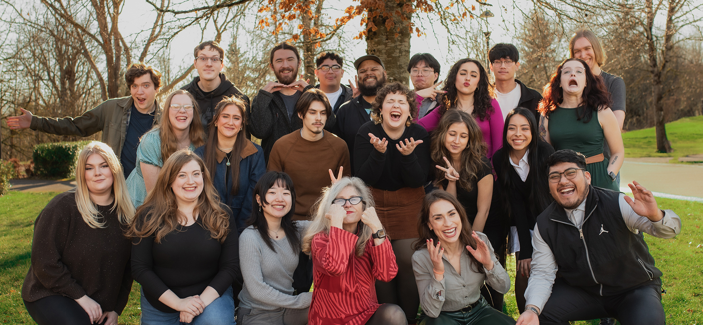 Group portrait of students and faculty gathered outdoors, posing together in three rows.