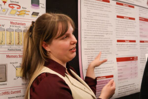 A student presenting a scientific research poster to peers at a WSU Vancouver academic showcase.
