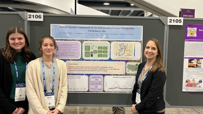 Student standing in front of her project poster.