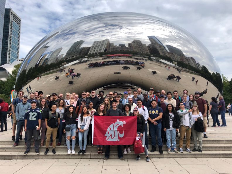 SDC Students gathered holding a wsu flag.