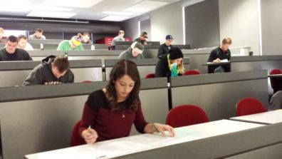 Students working in a large classroom.