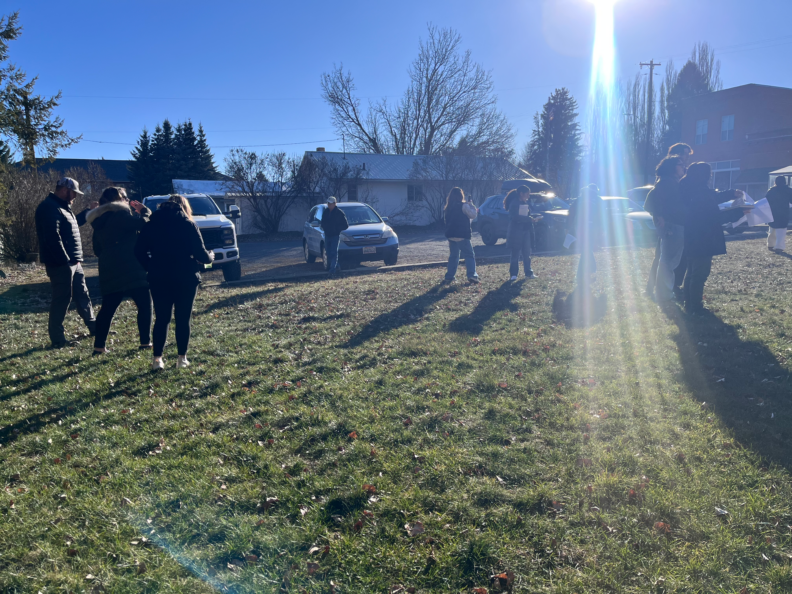 Many students gathered on a grassy lot.
