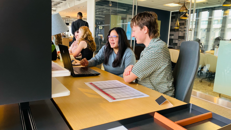 A student and instructor having a discussion in front of a computer.