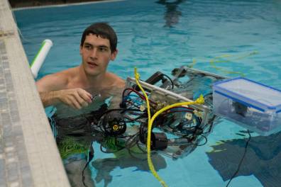 WSU student in a swimming pool with RoboSub at a competition