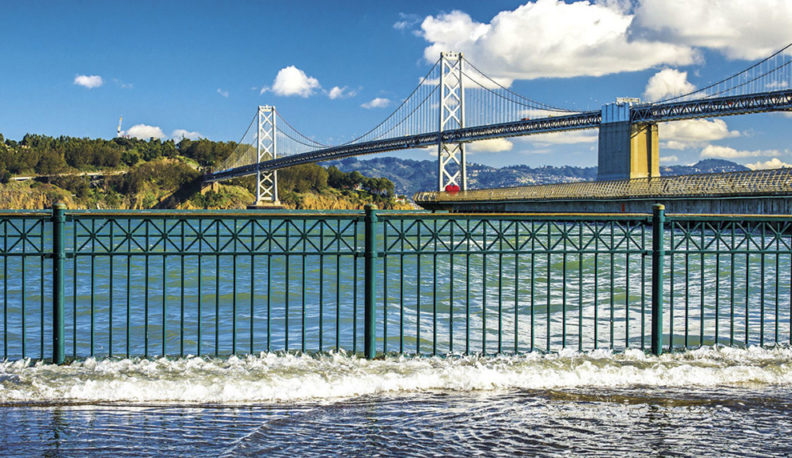 View of the Golden Gate Bridge from the Embarcadero in San Francisco, CA during king tide flooding.