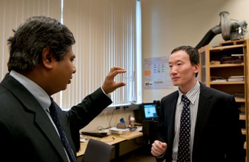 Dr. Dutta and Dr. Liu examining a glass slide used in microfluidics.