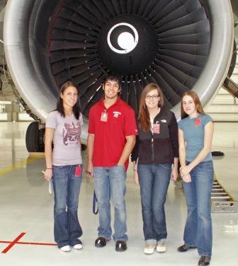 WSU engineering and business students pose in front of a plane turbine at Boeing.