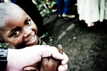 Young boy smiles up at the camera.