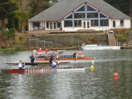 Two students canoeing on the WSU canoe along with other canoes and a boat on a river.