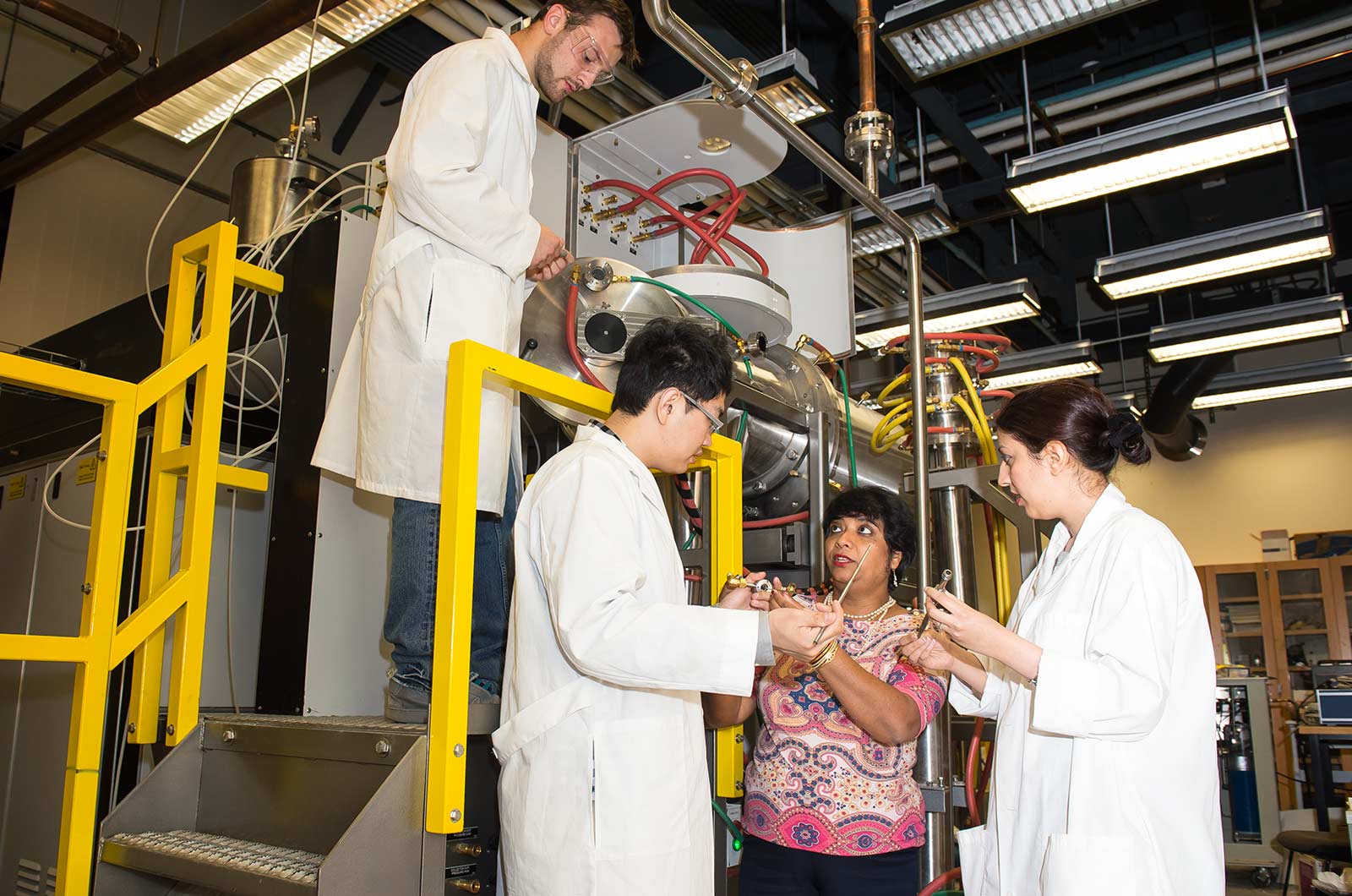 Susmita Bose instructs three students in the lab.