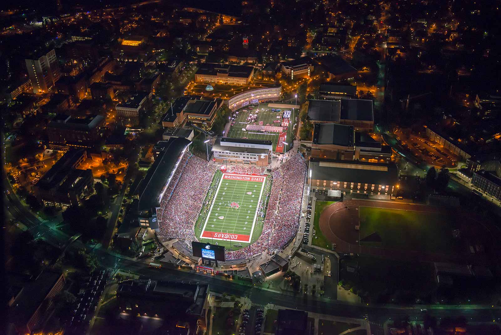 Aerial view of WSU Cougar's Martin Stadium during a nighttime football game.