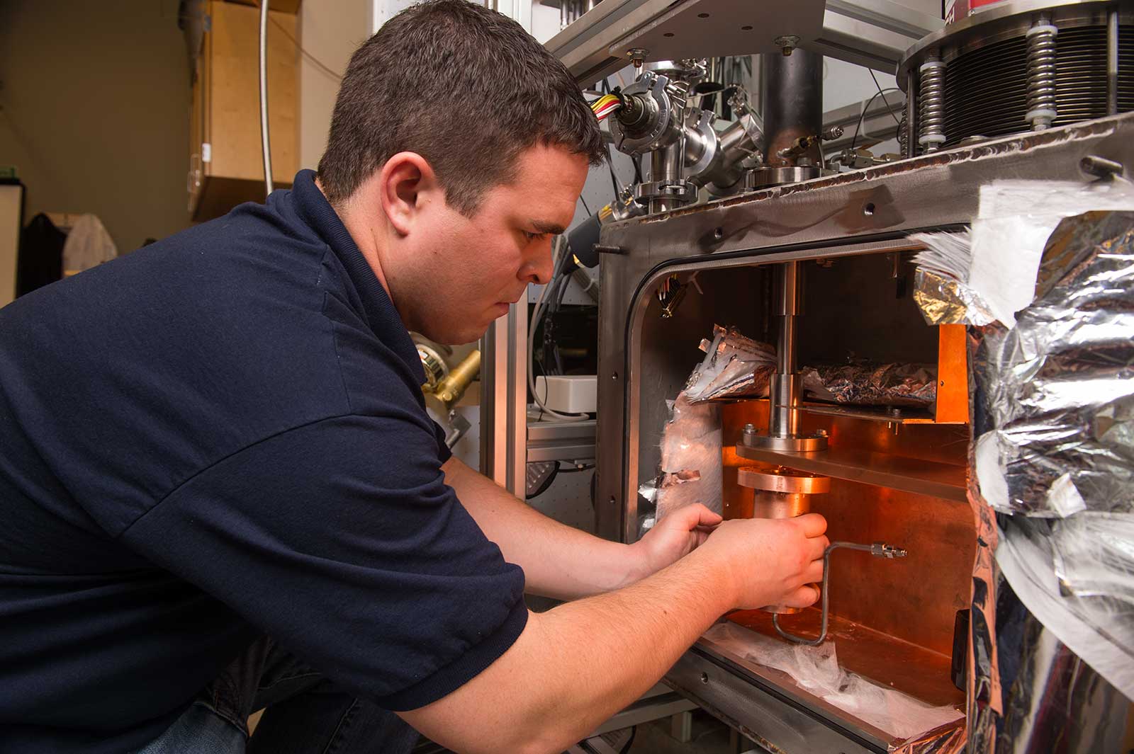 Ian Richardson installs a large magnet into machinery.