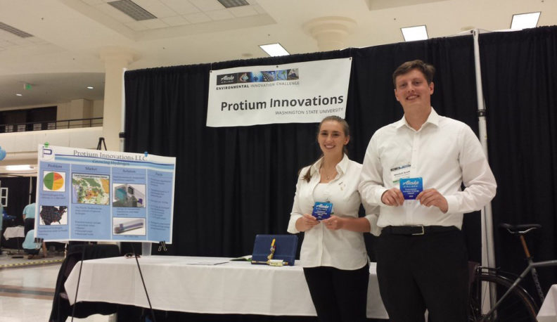 Bailee and Mitchell pose next to their product display.