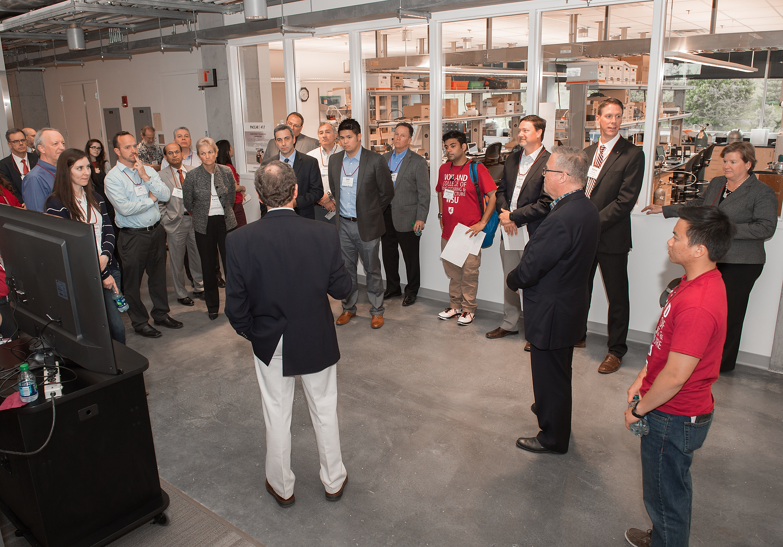 Tour group standing in a semicircle during a presentation.