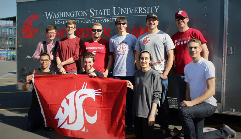 Ten members of the Mars Rover Team pose with the WSU flag.