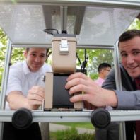 WSU engineering student Matthew McDaniel demonstrates the lift fixture to move a sample into a detection instrument system.