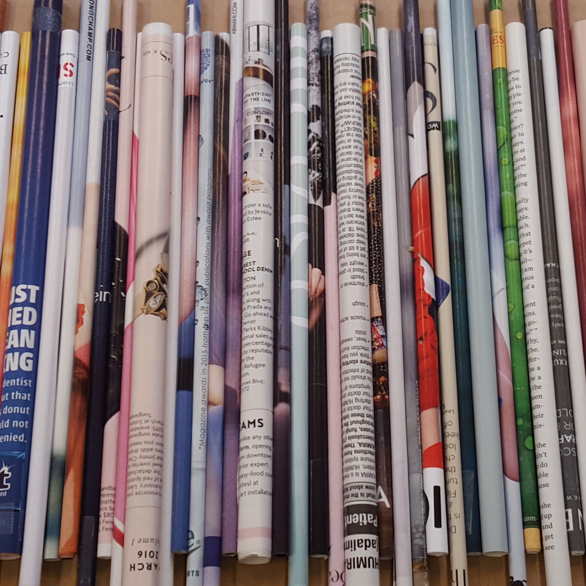Magazine pages rolled into tubes and placed side-by-side to form a wall.