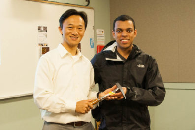 Two people pose with a chisel hammer.