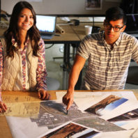 Two students at a drafting table.