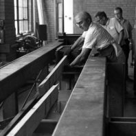 WSU Researcher moving a broken board in the wood lab circa 1960.