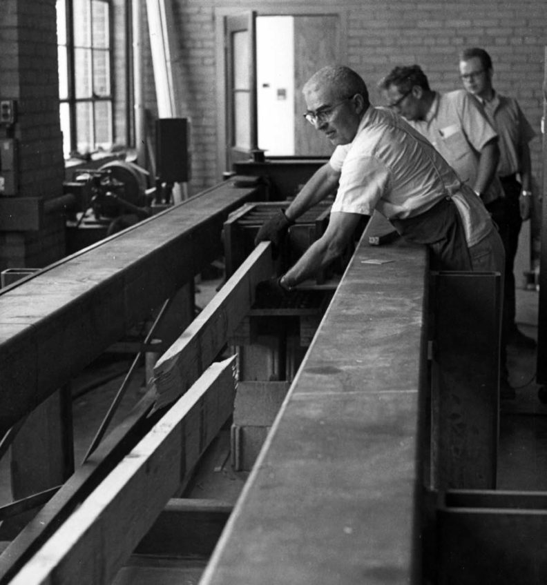 Researcher moving a broken board in the wood lab circa 1960.