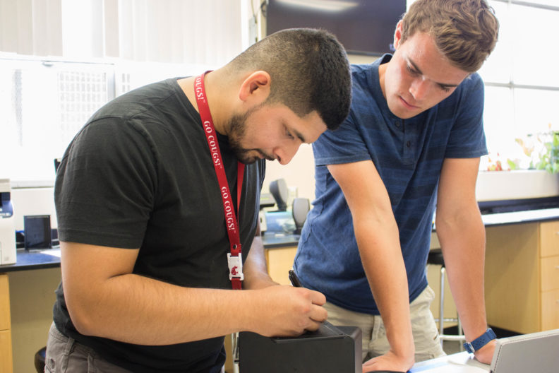 Two students work together at a lab station.
