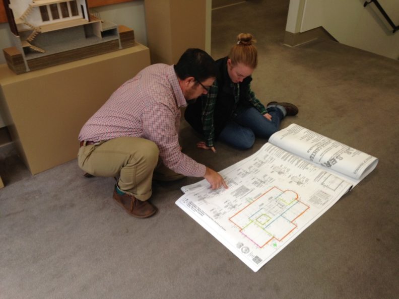 Peschel and a student examine a building blueprint.