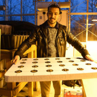 Electrical engineering student shows an aquaponic system for food sustainability.