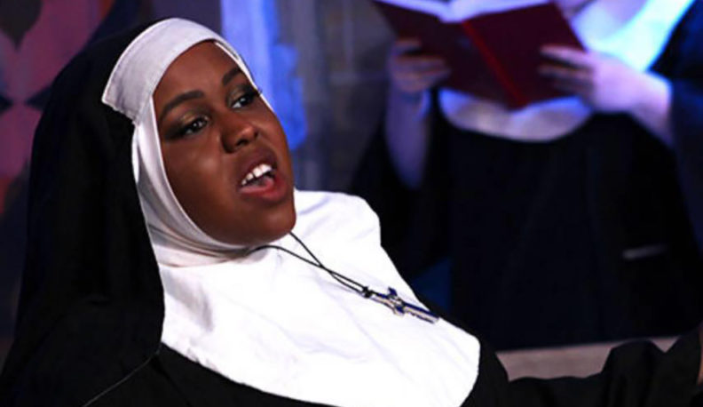 Cammi Smith sings on stage, dressed as a nun.