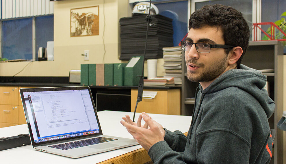 Kaveh Khorram sits at his laptop during an interview.